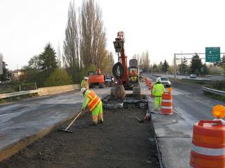 Image of a work crew with a lane closed and replacing a concrete panel in the roadway.
